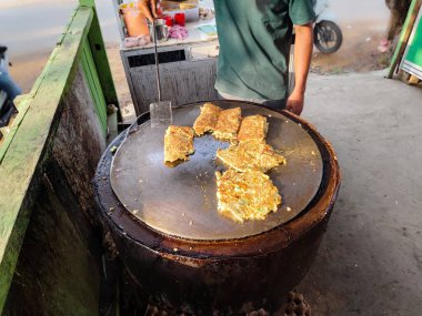 Sokak yemekleri, yumurta martabak satıcı düz tavada martabak pişiriyor.