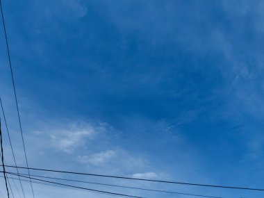 Yazın elektrik kablolarıyla bulutlu mavi gökyüzü manzarası