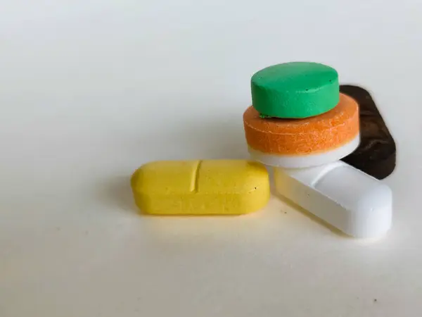 Beyaz arka planda izole edilmiş renkli ilaç haplarını kapat