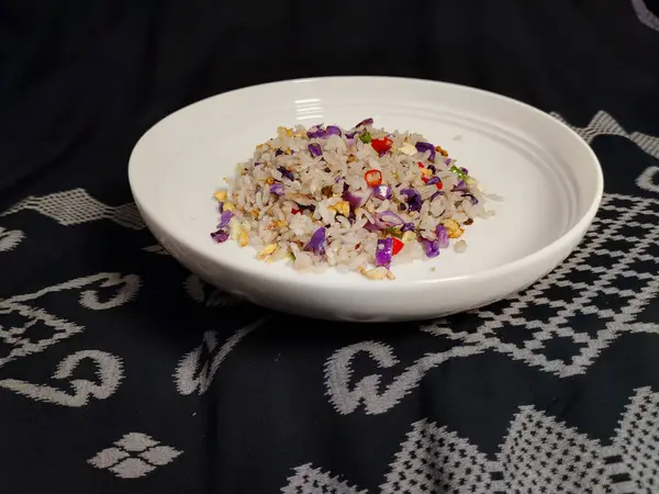 Sebzeli pilav ve siyah bez kaplı bir masa.