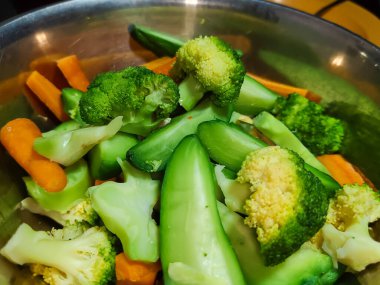 Buharda pişirilmiş sebzeleri paslanmaz bir kaseye koy.