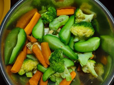 Buharda pişirilmiş sebzeleri paslanmaz bir kaseye koy.