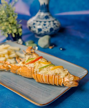 Mavi tabakta sebzeli ıstakoz ve yüksek kaliteli mavi arka plan.