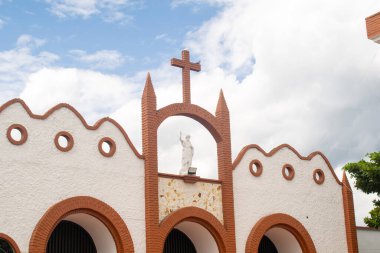 Üzerinde İsa 'nın heykeli olan kilise kulesinin çarpıcı bir görüntüsü, Kutsal Hafta' da çekildi. Bu fotoğraf dini bağlılığı, inancı ve Paskalya kutlamalarının ciddi atmosferini temsil ediyor.