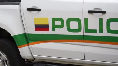 Kolombiyalı polis aracı yolda, devriye arabası şehir bölgesinden geçiyor, polis aracı hareket halinde.