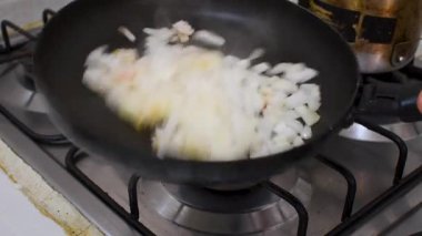 Tavada soğan kızartma, mutfakta soğan kızartma, kızartma tavasında doğranmış soğan kızartma. Yüksek kalite 4k görüntü