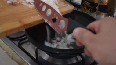 Sıcak tavada soğan kızartılıyor, ocakta sotelenmiş soğan pişiriliyor, yağda soğan parçaları pişiriliyor. Yüksek kalite 4k görüntü