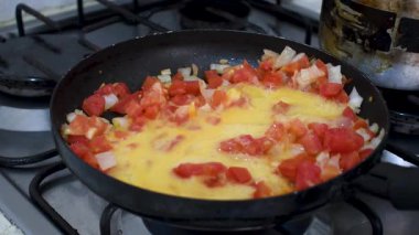 Kolombiya usulü omlet pişirmek, Domates ve soğanlı Huevos Pericos yapmak, Pan 'da geleneksel omlet hazırlamak. Yüksek kalite 4k görüntü