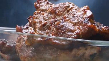 Cam bir kapta leziz ızgara et yakın çekim, dumanlı aroması ve dokusu sergileniyor..