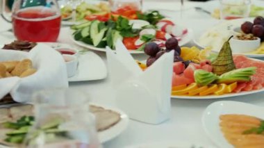 Taze meyve, salata ve aperatiflerle dolu zengin bir masanın yakın plan görüntüsü..