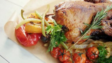 Biber, domates ve soğan gibi kavrulmuş sebzelerle servis edilen kızarmış ördeğin yakın çekimi..