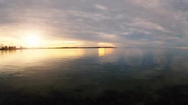 Sakin bir gölün üzerinde sakin bir gün doğumu.