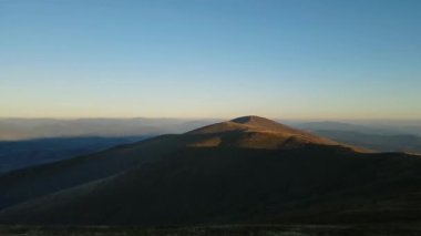 Gün batımında görkemli bir dağ sırasının nefes kesici panoramik manzarası..