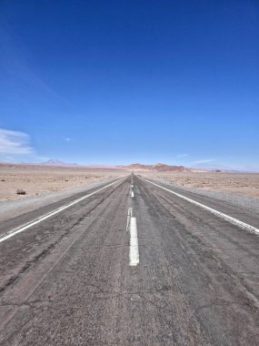 Mavi gökyüzünün altındaki sonu göremeden Atakama Çölü 'nde yol.