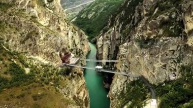 Flying Between Cliffs  A Journey Through Nature s Giant Walls. Stunning aerial footage glides smoothly between towering cliffs,revealing the raw grandeur of nature s architecture.The rocky walls rise dramatically on both sides,framing a narrow path