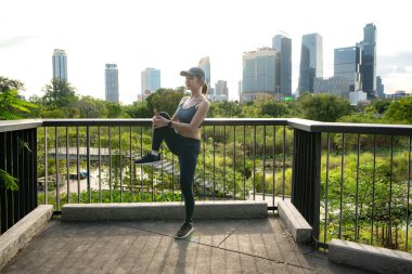 Genç bir kadın ve şehir parkında egzersiz zamanı.