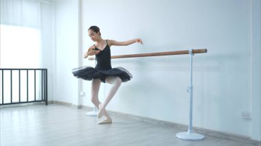 Kız bir bale öğrencisi beyaz bir geçmişle evde bale yapıyor.