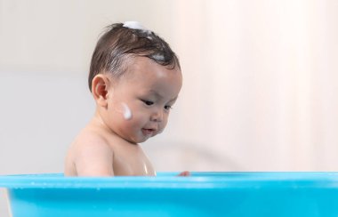 Anne bebeğe banyo yaptırdığında, o bundan zevk alıyor.