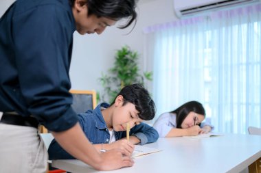 Küçük sınıf, öğretmenler ve öğrenciler sınıfta, dersleri gözden geçiriyorlar ve ev ödevi öneriyorlar.