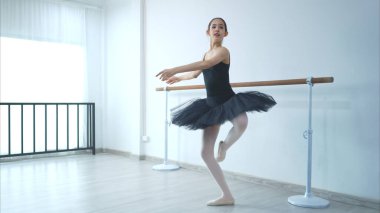 Kız bir bale öğrencisi beyaz bir geçmişle evde bale yapıyor.
