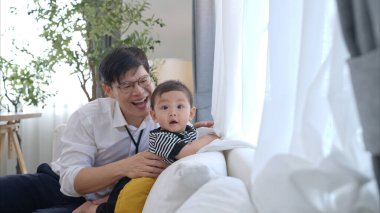 Baba ve oğul işten eve döndükten sonra birlikte oynuyorlar.