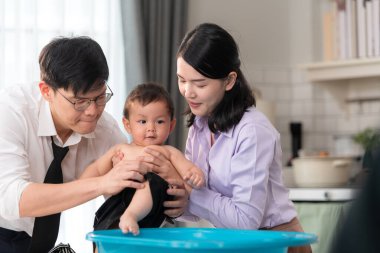 Anne ve baba, işten döndükten sonra oğullarını yıkıyorlar.