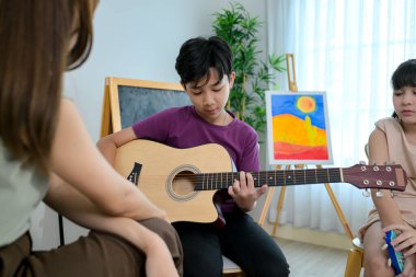 Gitar sınıfı, öğretmen ve öğrenciler müzik sınıfında.