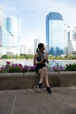 Genç bir kadın ve şehir parkında egzersiz zamanı.