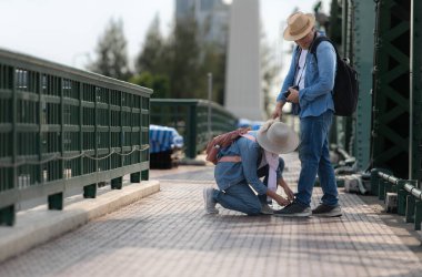 Yaşlı çiftler Tayland 'ın Bangkok kentindeki eski demir köprü (Phra Phutthayotfa Köprüsü) üzerinde seyahat ederler.