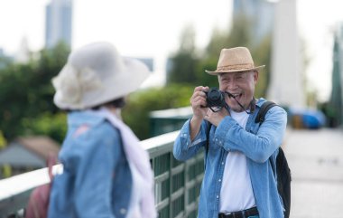 Yaşlı çiftler Tayland 'ın Bangkok kentindeki eski demir köprü (Phra Phutthayotfa Köprüsü) üzerinde seyahat ederler.