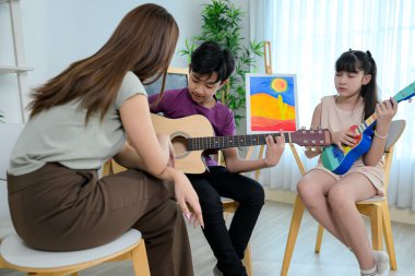 Ukelele ve Gitar sınıfı, öğretmenler ve öğrenciler müzik sınıfında
