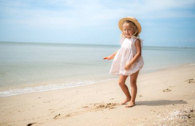 Çocuklar kumsalda oynar ve dinlenir.