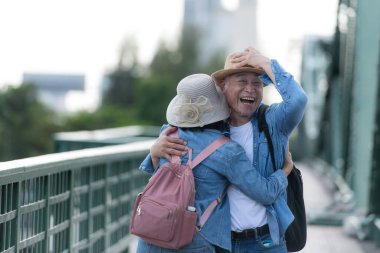 Yaşlı çiftler Tayland 'ın Bangkok kentindeki eski demir köprü (Phra Phutthayotfa Köprüsü) üzerinde seyahat ederler.
