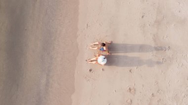 Sahilde dinlenen bir ailenin üst görüntüsü.