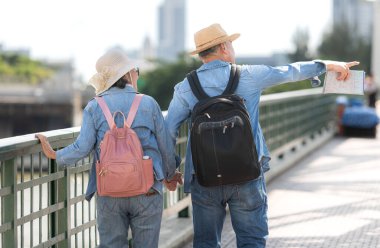 Elderly couples travel on the old iron bridge (Phra Phutthayotfa Bridge) in Bangkok, Thailand clipart