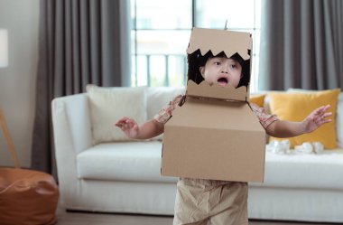 En sevdiği dinozor figürlü özel bir çocuk, evin oturma odasında eğleniyor.