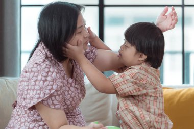 Özel bir çocuk ve annesi evin oturma odasında tatilde eğleniyor ve dinleniyorlar.