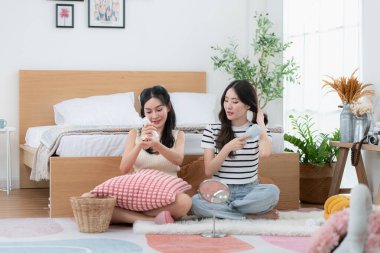 Asyalı genç kadınlar haftalık tatil rutinlerini uyguluyor. Kalkıyor, makyaj yapıyor ve dinleniyorlar.