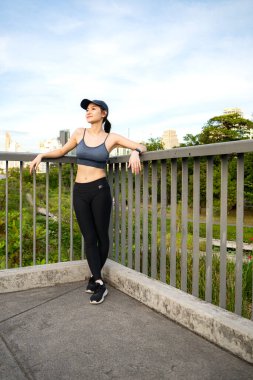 Genç bir kadın ve şehir parkında egzersiz zamanı.