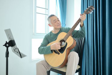 Usta bir gitarist evde müzik çalıyor.