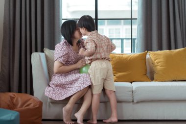 Özel bir çocuk ve annesi evin oturma odasında tatilde eğleniyor ve dinleniyorlar.