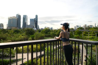 Genç bir kadın ve şehir parkında egzersiz zamanı.