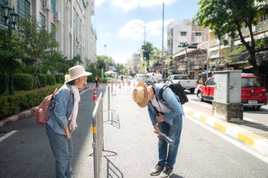 Tayland 'ın eski Bangkok şehrinde yaşlı bir çift caddede yürüyor.
