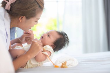 Bir anne, sıcak ve aile dolu bir yatak odasında küçük kızıyla oynar..
