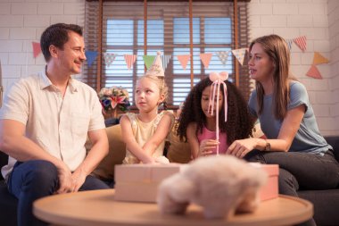 Ebeveynler ve çocuklar doğum günü partisinin tadını çıkarıyorlar.