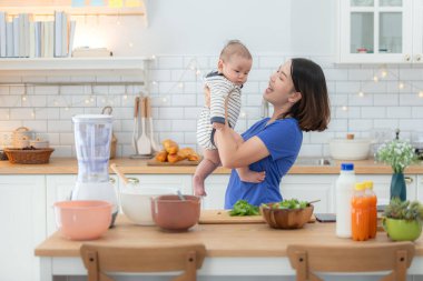 Anne ve küçük çocuk mutfakta yemek hazırlıyorlar.