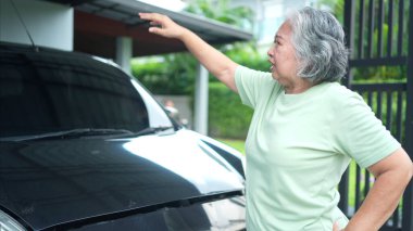 Büyükanne, ebeveynlerinin otomobillerini temel motor kontrolünden geçirir.