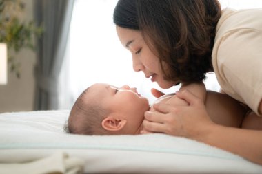 Minik bir çocuk yatakta mutlu bir şekilde gülümser. Annesini bekler. Banyo yaptıktan sonra pudra sürer ve elbiselerini giyer.