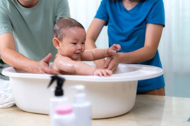 Ebeveynler yemek yedikten sonra küçük çocuğu yıkıyor.