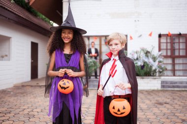 Hayalet kostümlü çocuklar Cadılar Bayramı 'nda şeker mi şaka mı oynuyorlar.